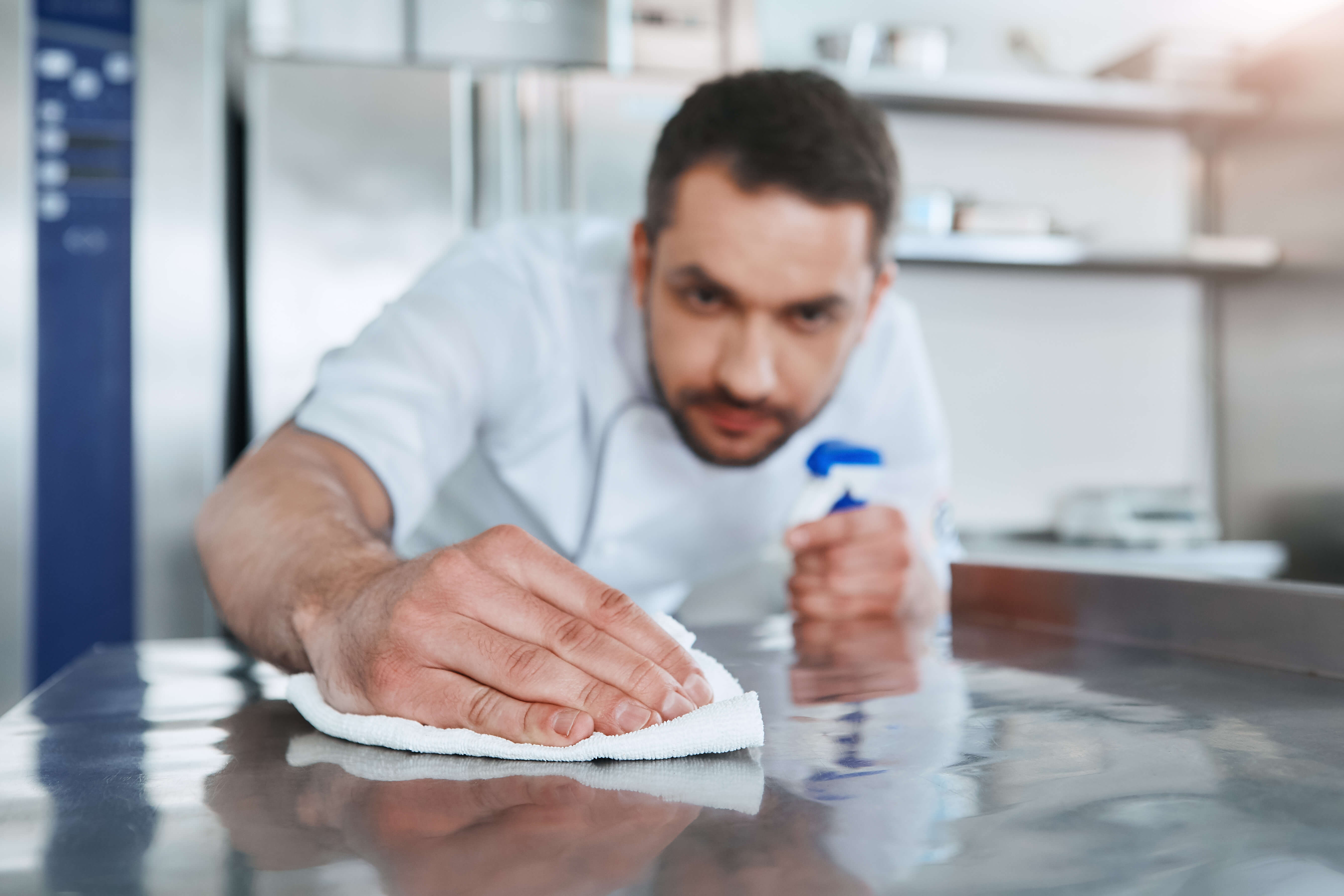 A chef wiping down a cooking surface